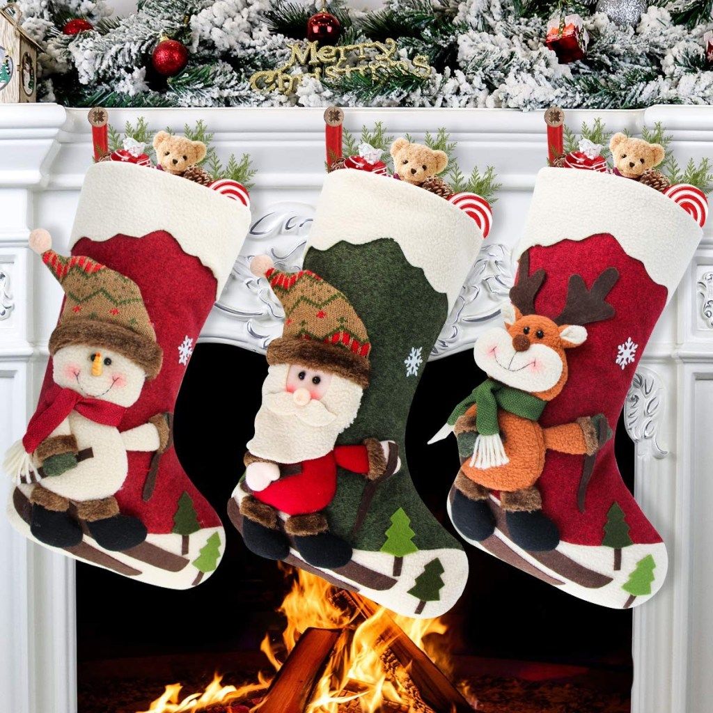 tri čarape s 3d zimskim likovima obješene o plašt