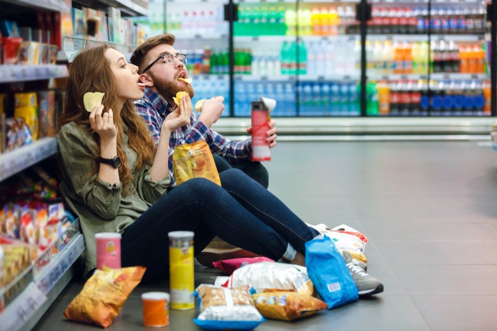 Двойка, която се храни, докато пазарува хранителни стоки Незаконни неща