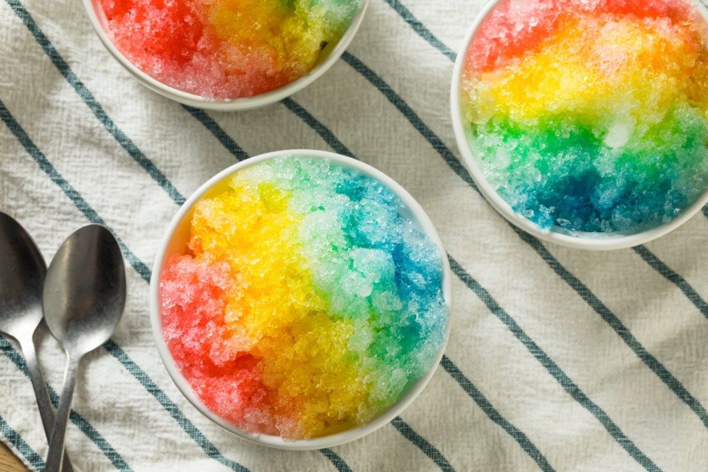 skåle med regnbue-snekegler eller barberet is på stribet duge