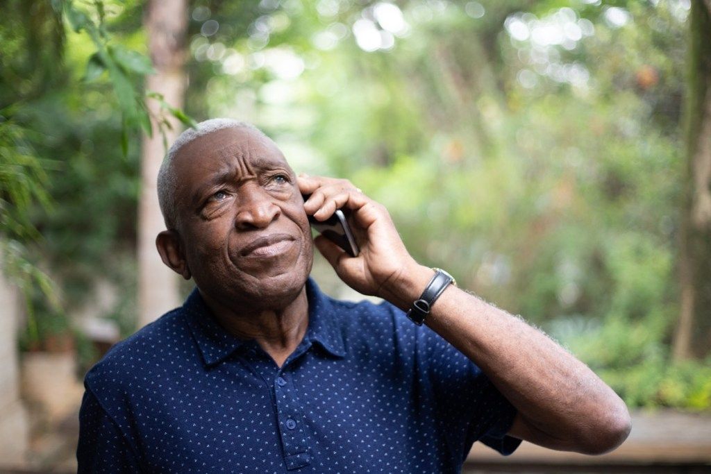 ชายสูงอายุพยายามโทรหาใครบางคนทางโทรศัพท์มือถือ