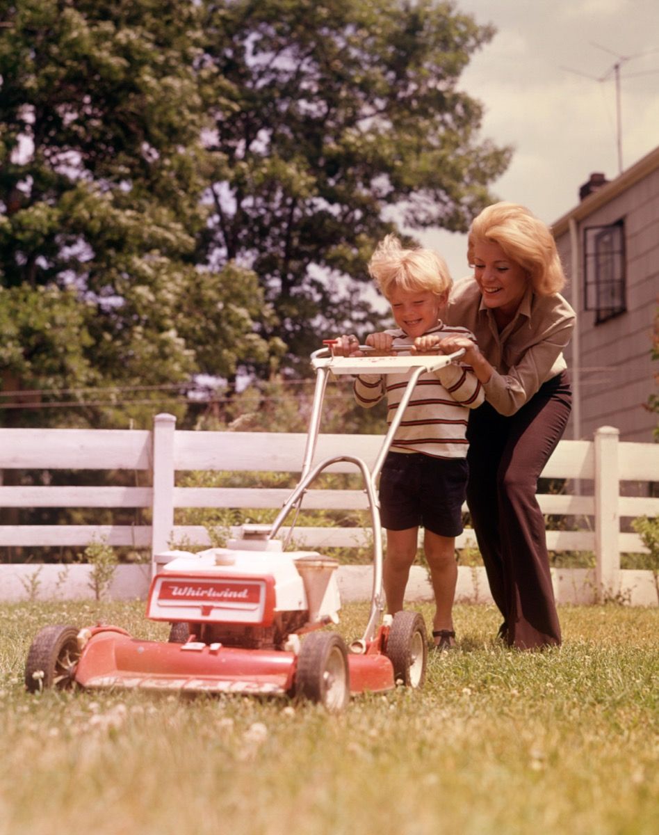แม่และลูกชายปี 1960 ตัดหญ้าที่บ้านหลังใหญ่