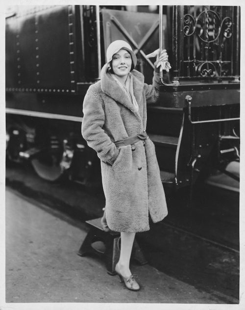   लुपे वेलेज़ लगभग 1929 में एक ट्रेन के बगल में खड़ा था