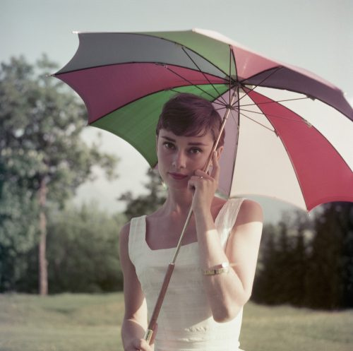   Audrey Hepburn fotografiada sosteniendo un paraguas en Suiza en 1954