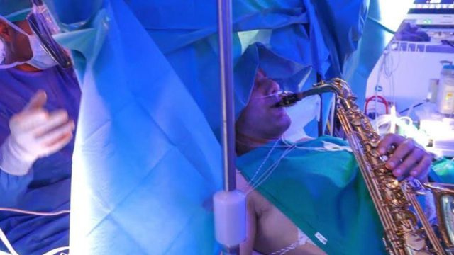 Музикант свири на саксофон по време на 9-часовата си мозъчна операция