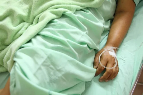   zblízka ženy's hand in hospital bed