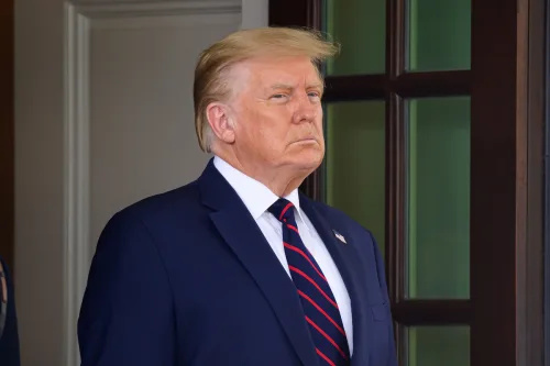  Доналд Тръмп изглежда сериозно в тъмносин костюм, бяла риза и вратовръзка в синьо и червено