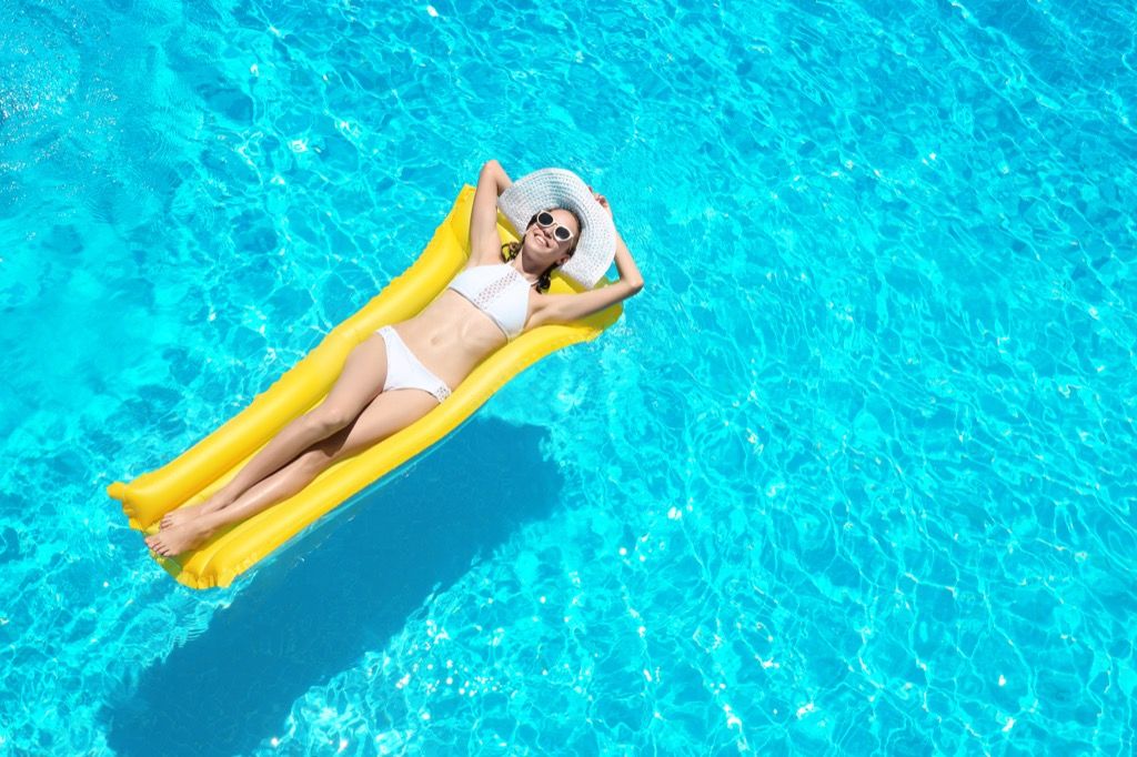 Krásna slobodná žena vyhrievajúca sa v bazéne.