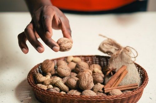nainen poimii pähkinän korista pähkinöitä