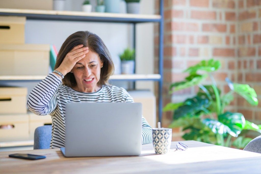 Kvinne på en bærbar datamaskin som ser stresset og sint ut