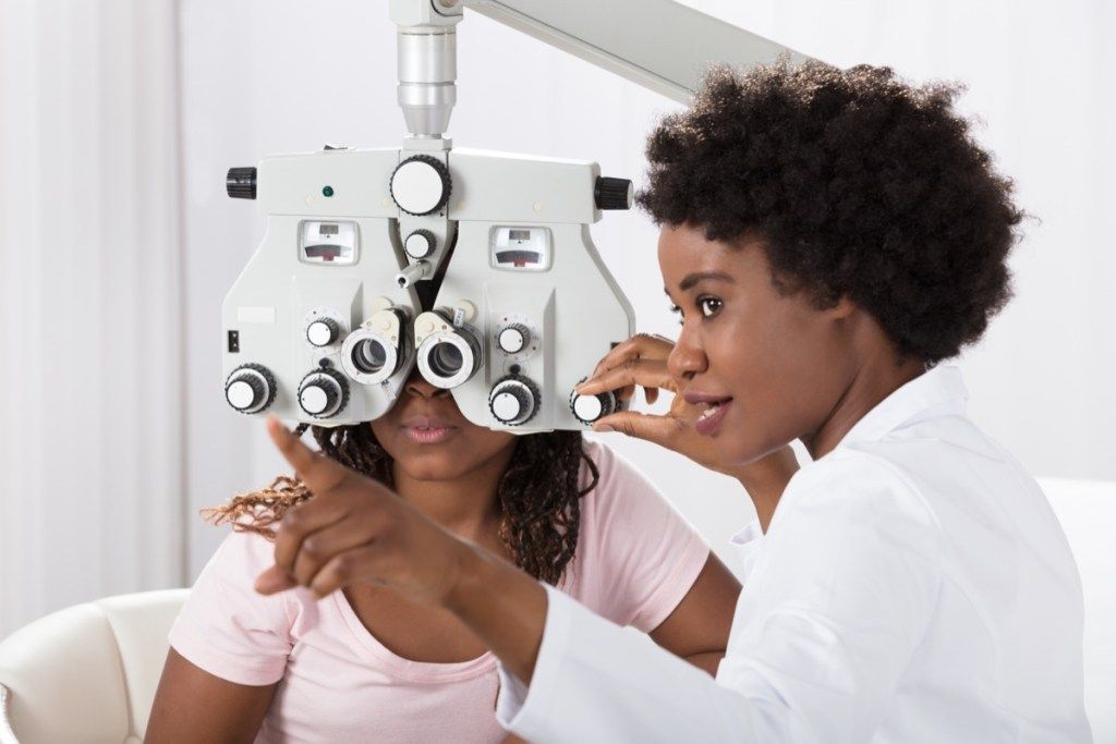 mujer negra, doctor, administrar, examen ocular, a, paciente joven