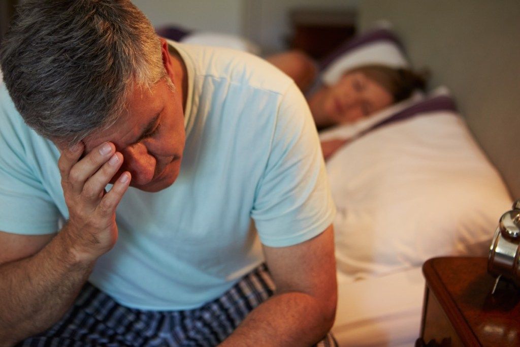 Мъж, стресиран в леглото, страдащ от ниско либидо