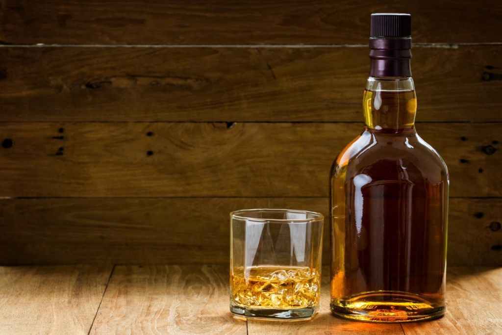 whiskyflaska och glas på träbord