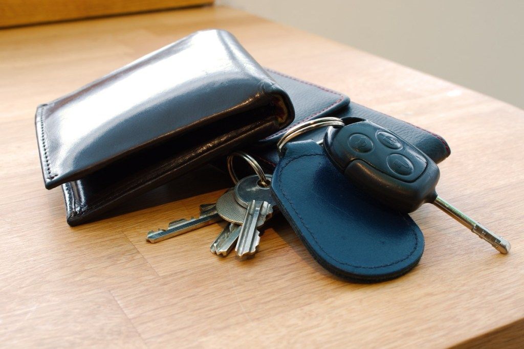 piniginė ir automobilio raktai ant stalo