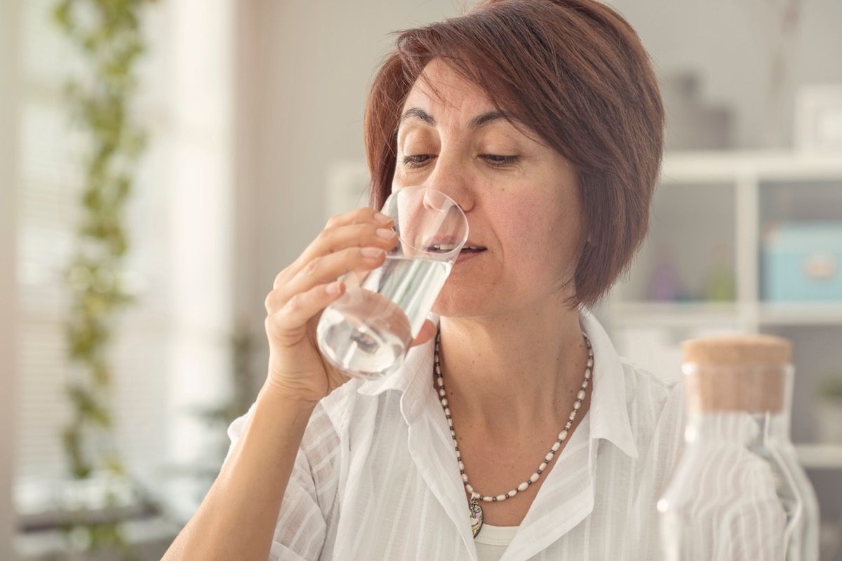 Mujer de edad bebiendo un vaso de agua