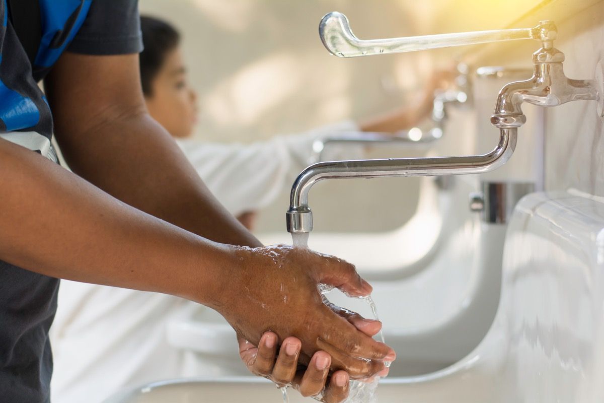 cilvēks mazgā rokas pie izlietnes