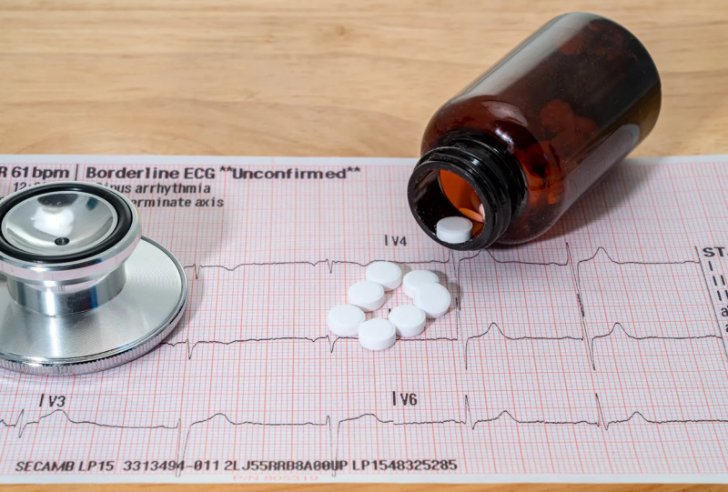   錠剤が瓶からこぼれる心電図検査チャート。