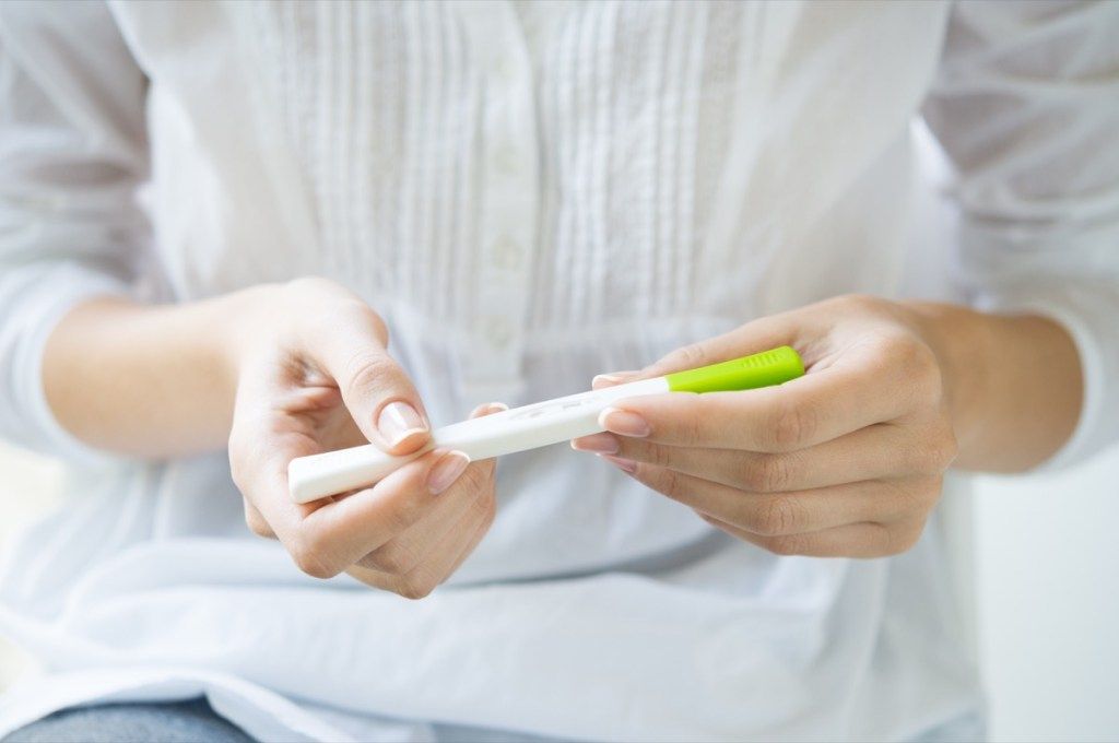 महिला हाथों में गर्भावस्था परीक्षण रखती है, यह क्या है