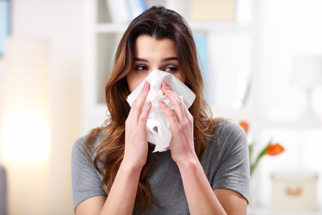 Mujer estornudando por alergias