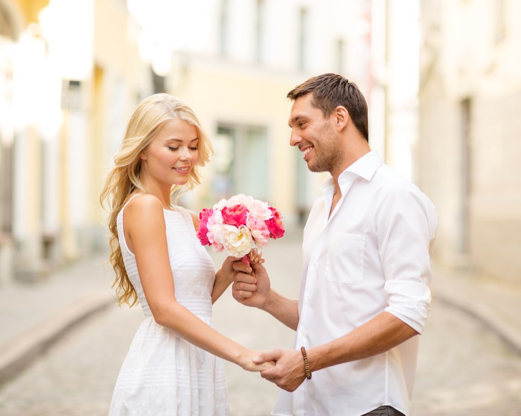 Άνδρας που δίνει γυναίκα ρομαντική λουλούδια
