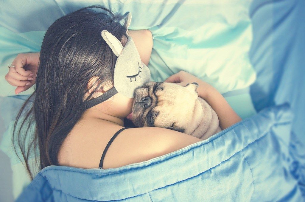 Mujer durmiendo en la cama con perro {Beneficios de llorar}