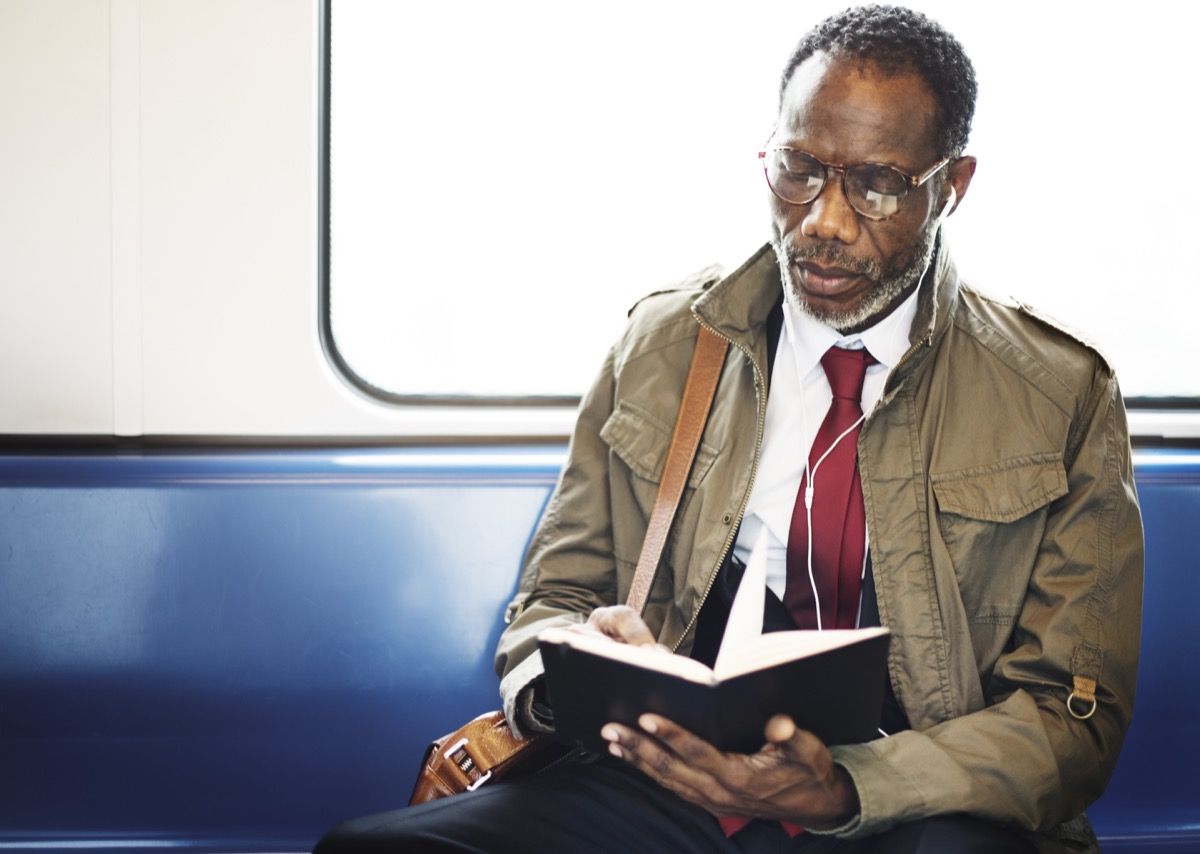 ผู้ชายกำลังอ่านหนังสือบนรถไฟใต้ดิน {Small Resolutions}