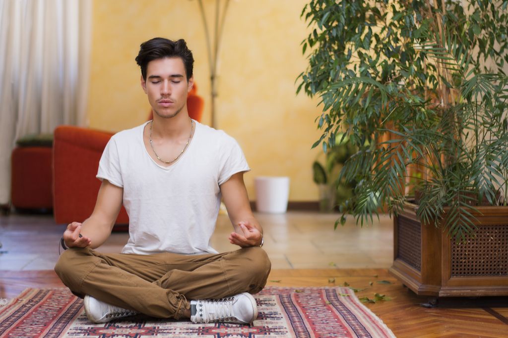 Mann som mediterer hjemme anti-aldring