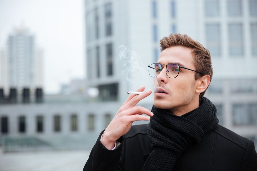 Affärsman som röker cigarett mot åldrande