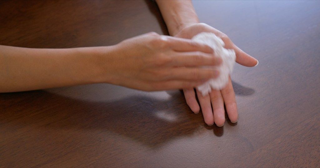 mujer limpiando sus palmas con un pañuelo
