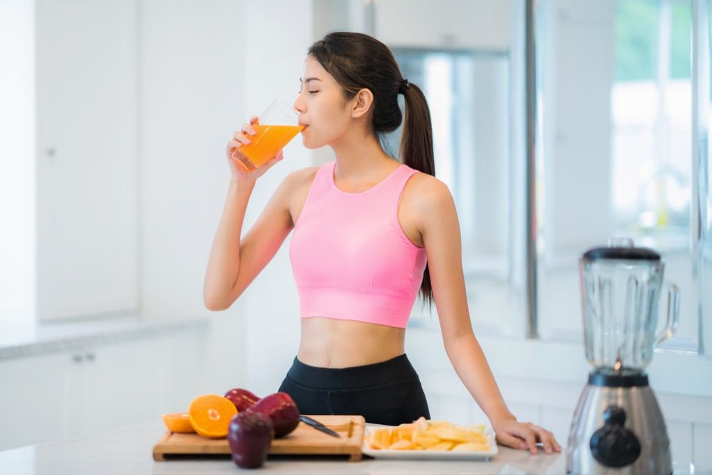 mujer bebiendo jugo de naranja, síntomas estomacales