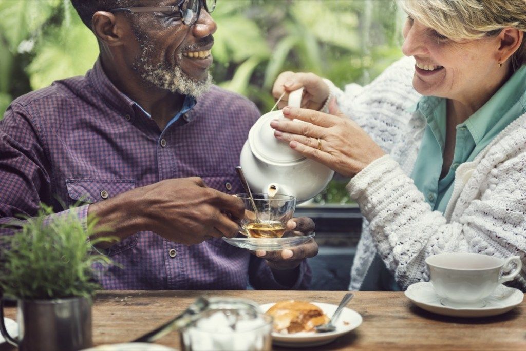Amigos adultos mayores en un café bebiendo té verde reducen la presión arterial naturalmente