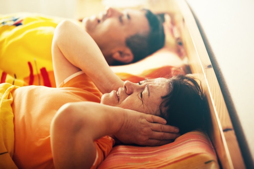 Kvinne som dekker ørene fordi mannen hennes snorker, viser at du trenger en ny madrass