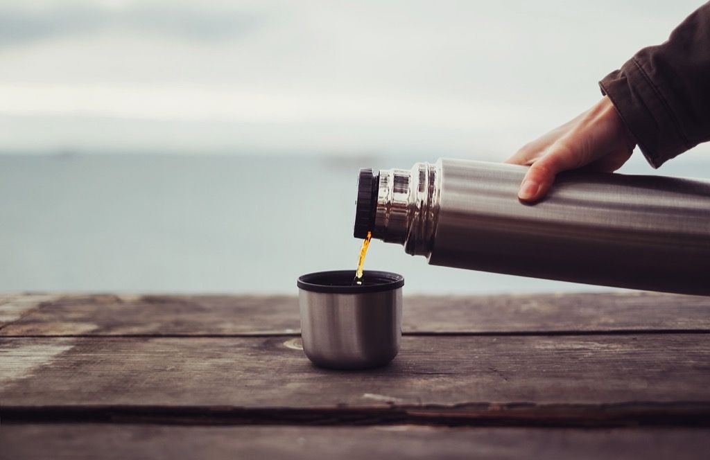Frau gießt Kaffee aus der Thermoskanne