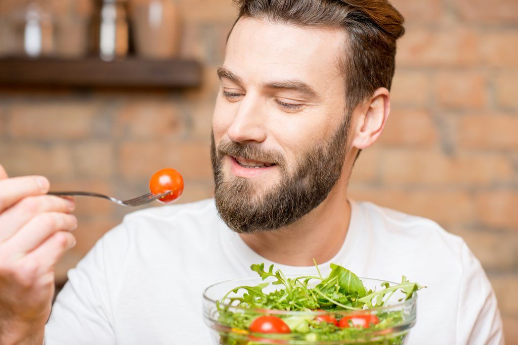 Hombre comiendo tomate anti-envejecimiento