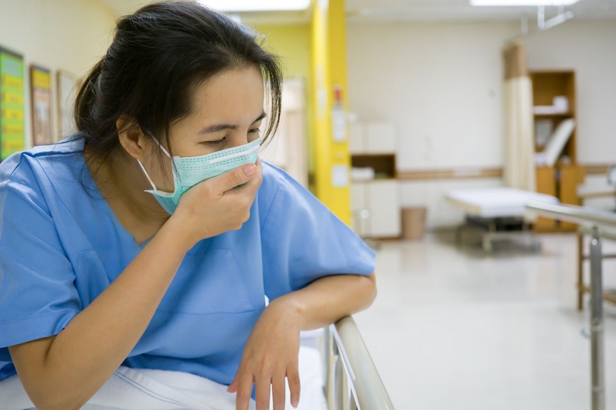 paciente do sexo feminino tossindo consultório médico