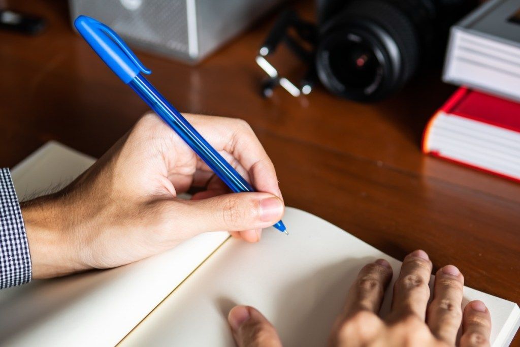 Pisanie dla lewych w notesie z niebieskim długopisem, sposoby na to, by poczuć się niesamowicie
