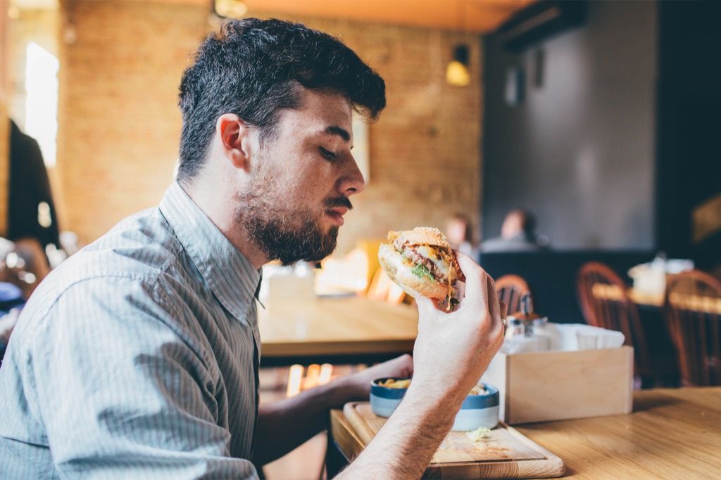 čovjek jede hamburger partner
