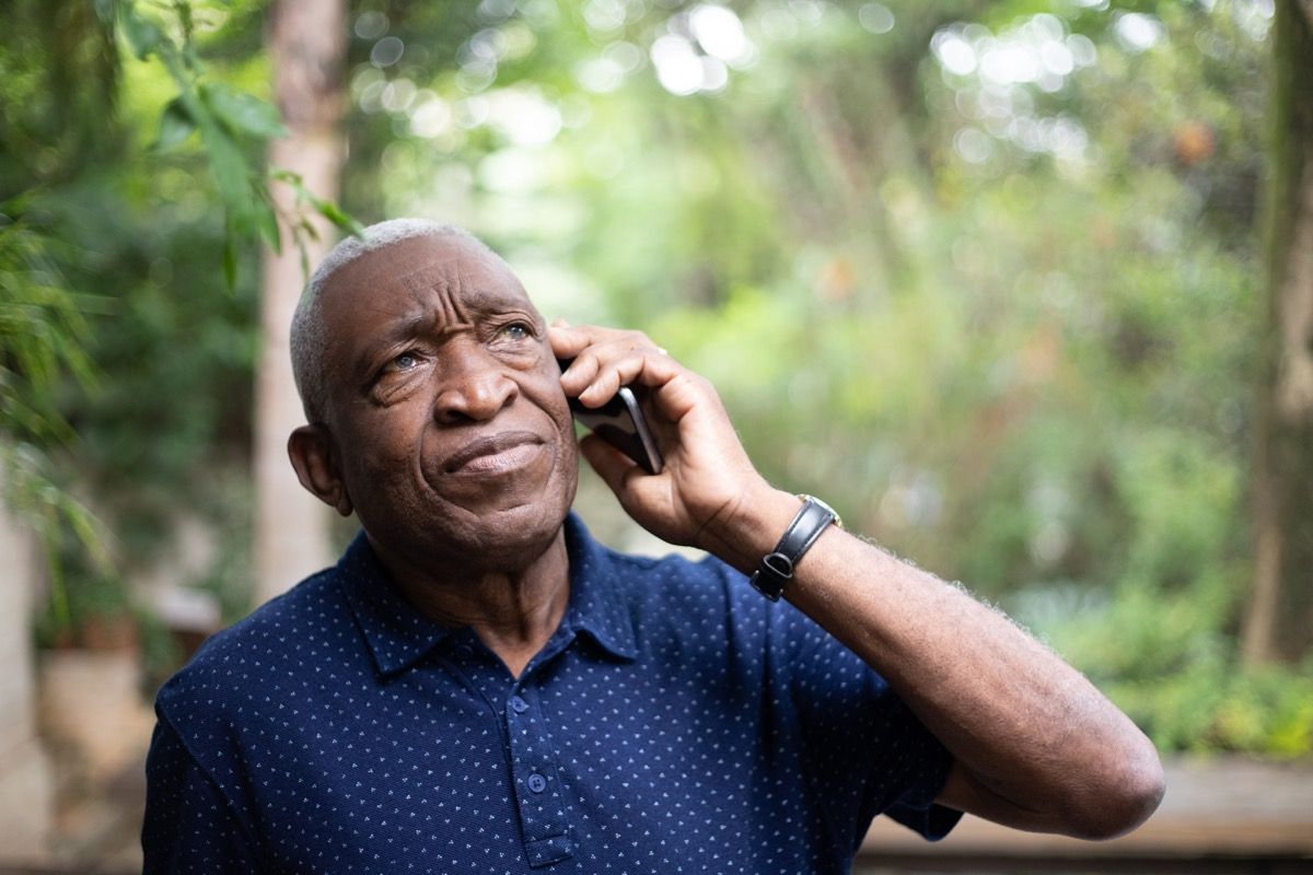 oudere man die iemand op zijn mobiele telefoon probeert te bellen