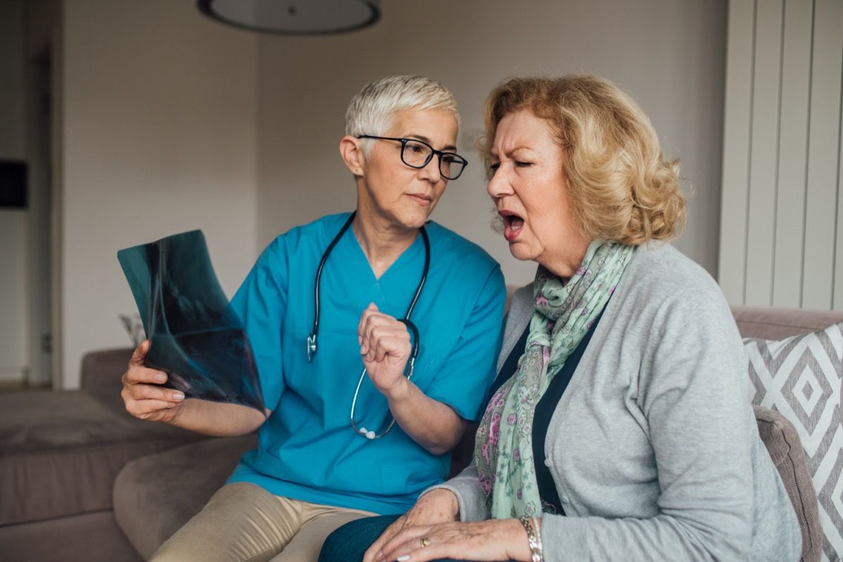 ηλικιωμένη γυναίκα κοιτάζοντας ακτινογραφία με γιατρό και ζητώντας ερωτήσεις