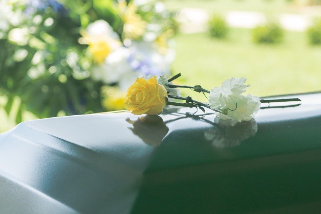 फूलों के एक करीब एक अंतिम संस्कार कास्केट बाहर रखा है