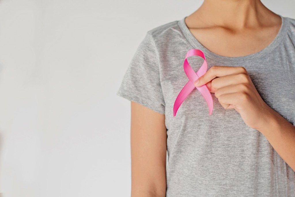 жена държи розова панделка за рак на гърдата