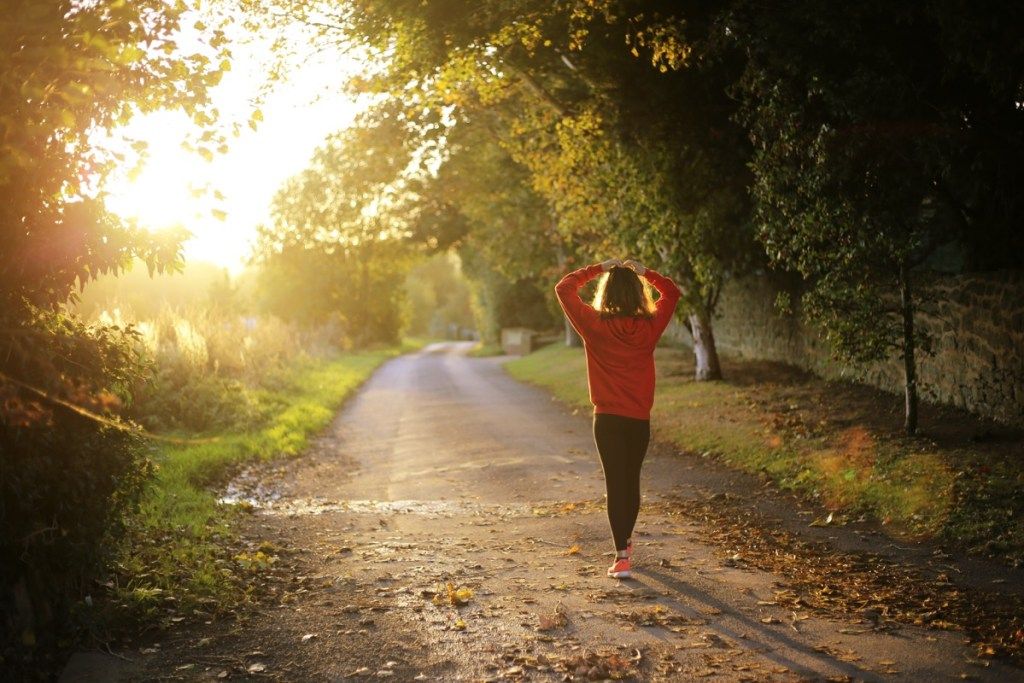 Kvinde løber udenfor i efteråret falder vejr sundhed