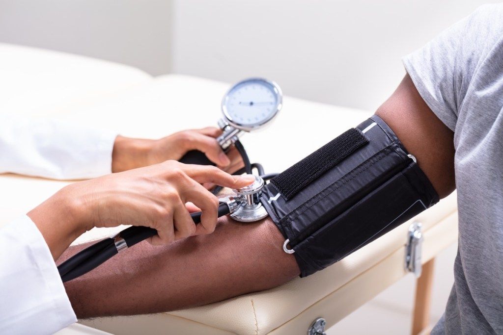 Medico che controlla la pressione sanguigna
