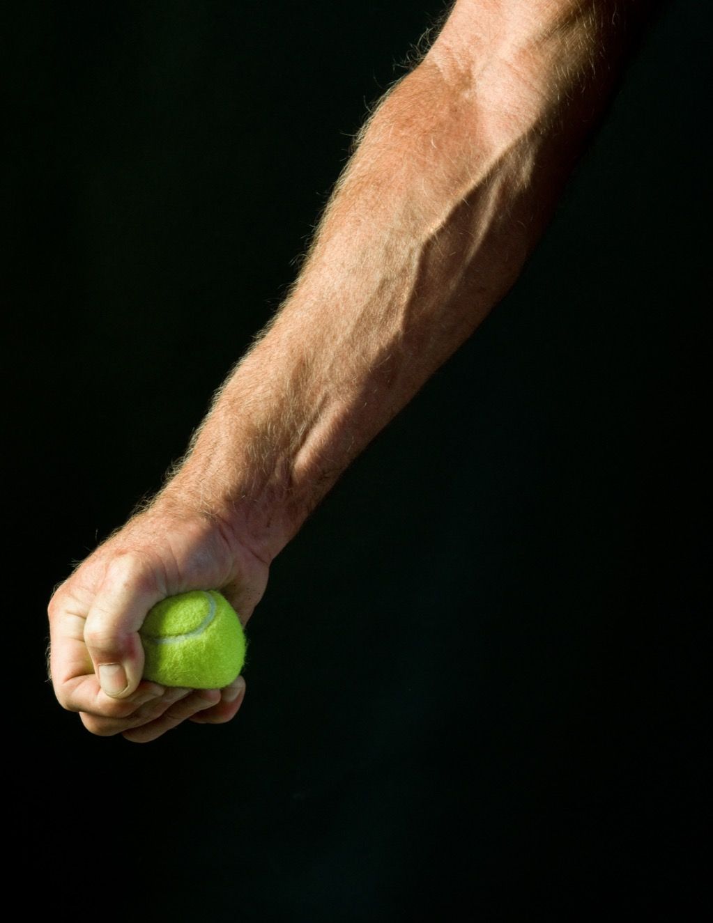Mies puristamalla tennispalloa matalalle verenpaineelle.