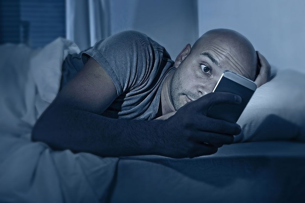 stresset mobiltelefon i sengen