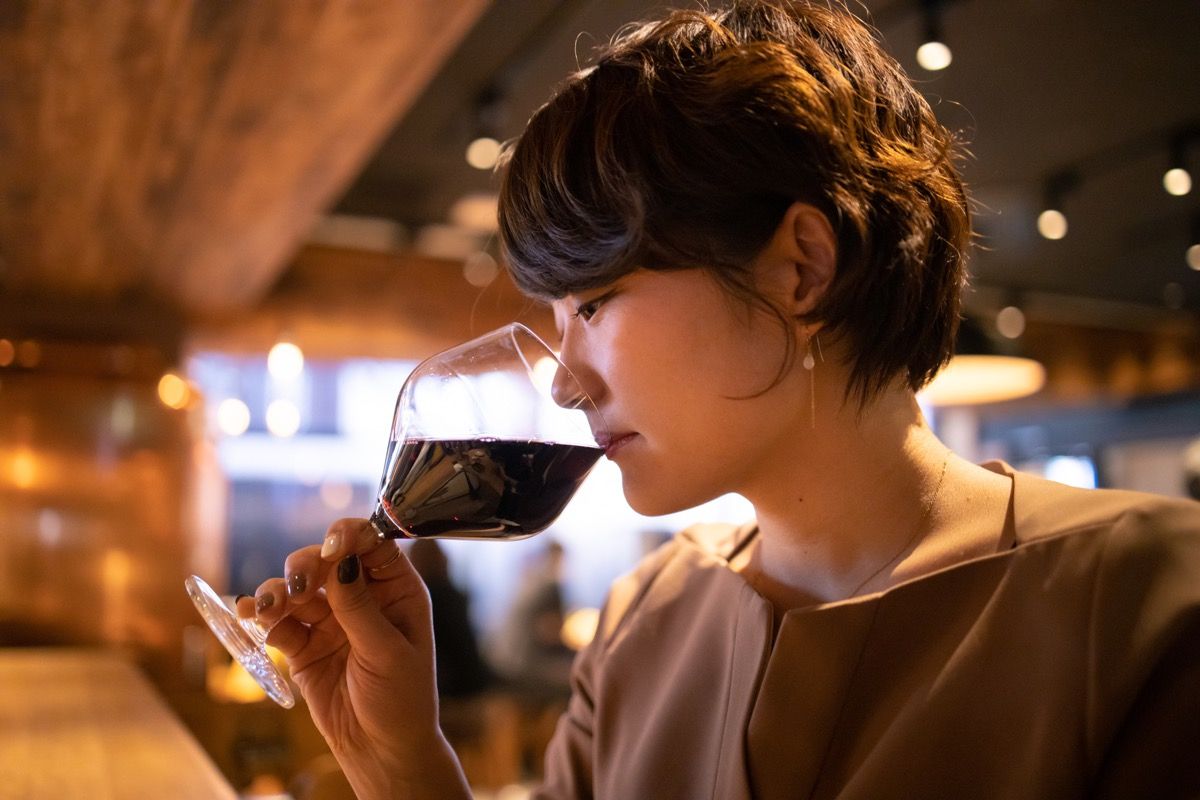 バーで赤ワインを飲む若い女性