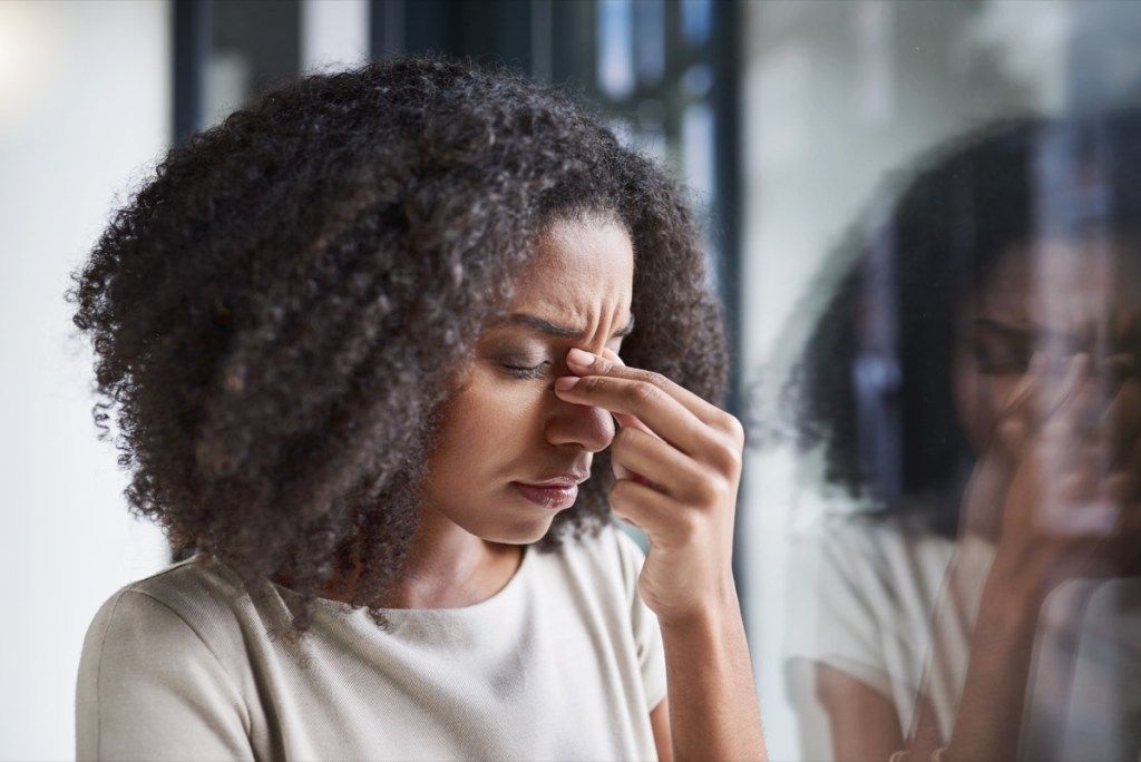 Imagine tăiată a unei tinere femei de afaceri atrăgătoare care suferea de dureri de cap în timp ce stătea în biroul ei
