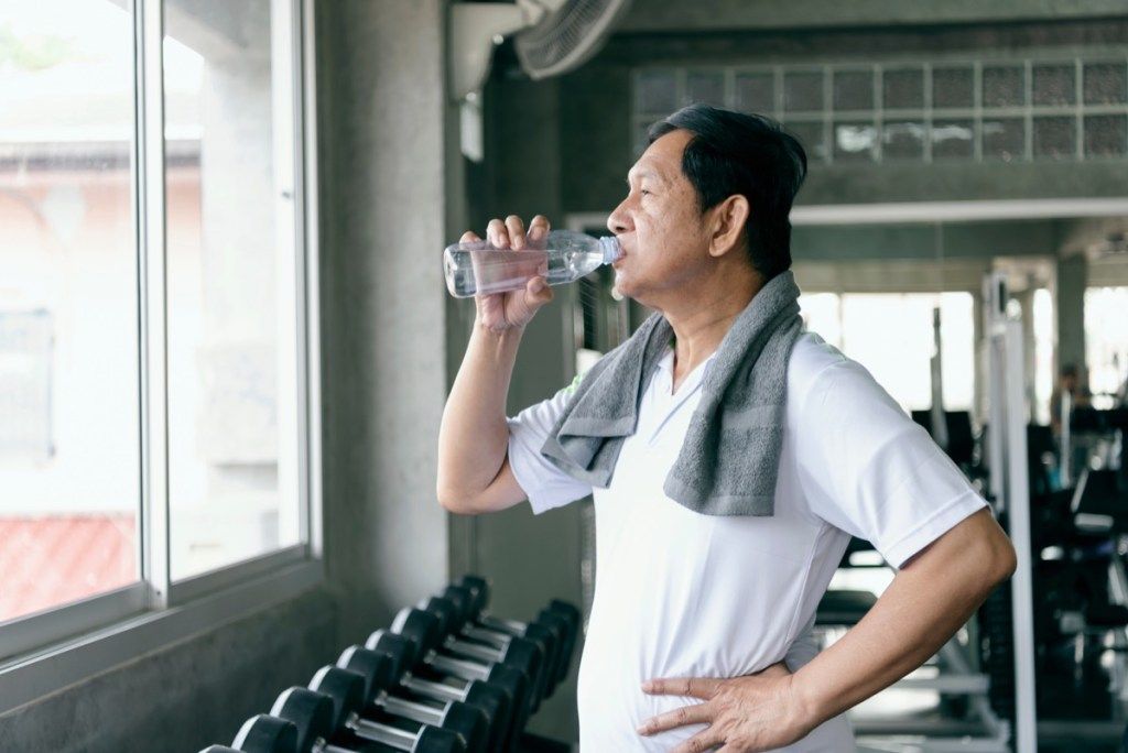 بوڑھا آدمی ورزش کرنے کے بعد پانی پیتا ہے ، صحت مند آدمی