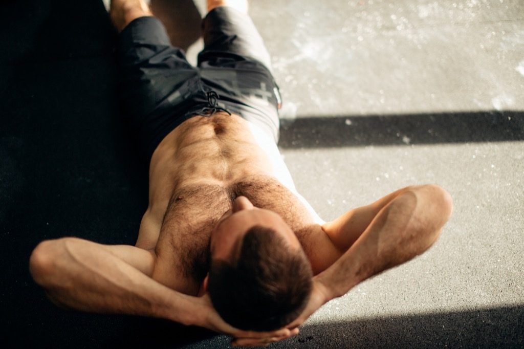 Mann macht Crunches Übungen zum Hinzufügen von Muskeln