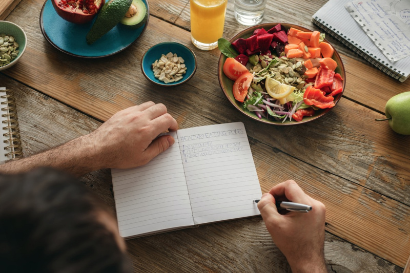   Der Mensch macht eine Liste mit gesunden Lebensmitteln. Gesundes Lebensstil-Diät-Lebensmittelkonzept