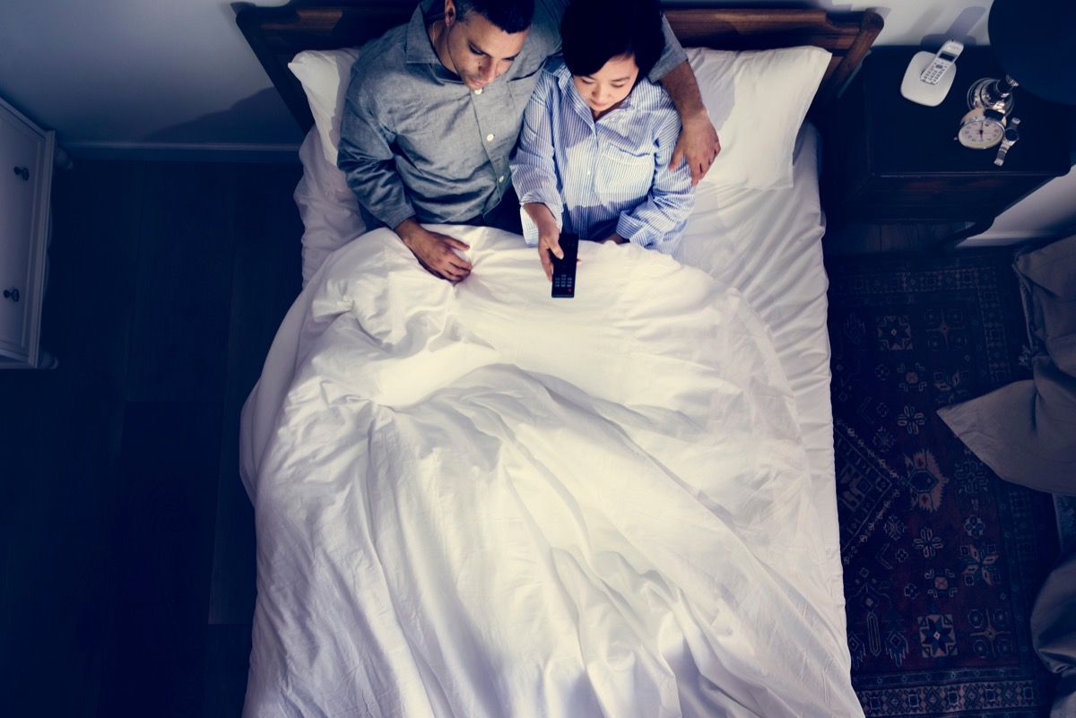 par iført pyjamas i sengen, bladrer gennem kanaler på fjernsynet - hvor ofte har par sex